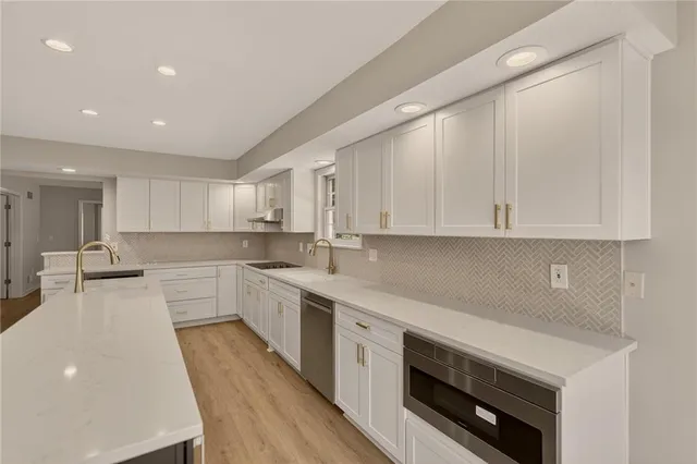 a kitchen with white cabinets appliances and sink