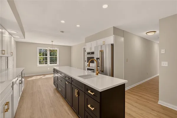 a kitchen with granite countertop a sink and a refrigerator