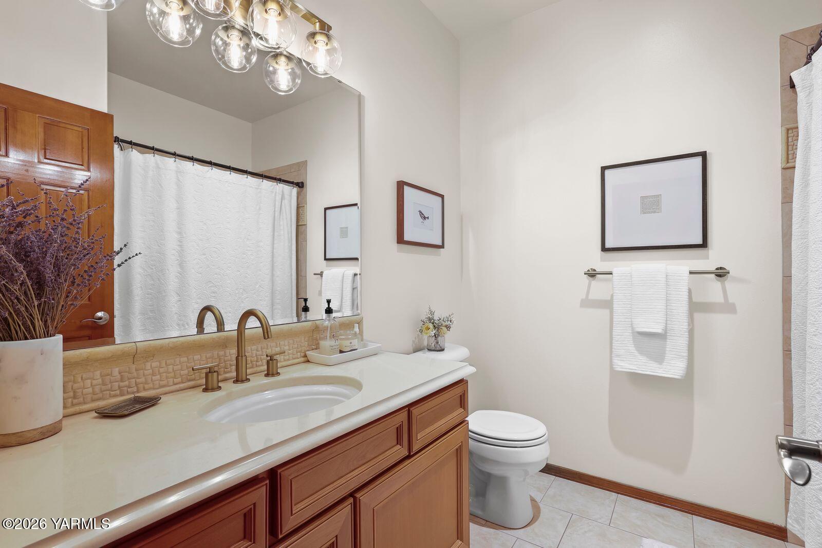 11105 Zier Road Yakima, WA 98908 - Photo 25 of 65 a bathroom with a granite countertop sink a toilet and a mirror