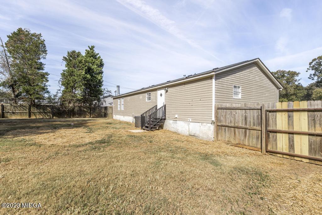 208 Colonial Drive Byron, GA 31008 - Photo 35 of 38 a backyard of a house with wooden fence and large trees