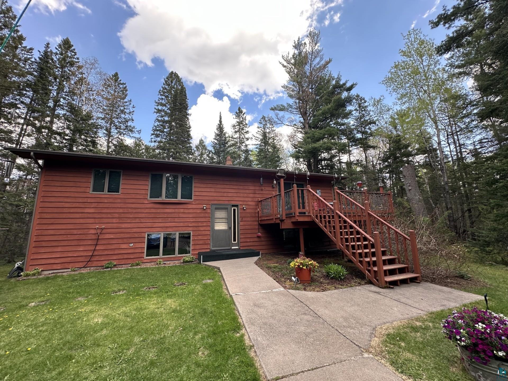81 Hautaluoma Road Esko, MN 55733 - Photo 1 of 43 Red horizontal siding exterior with a multi-level wood deck and stairs