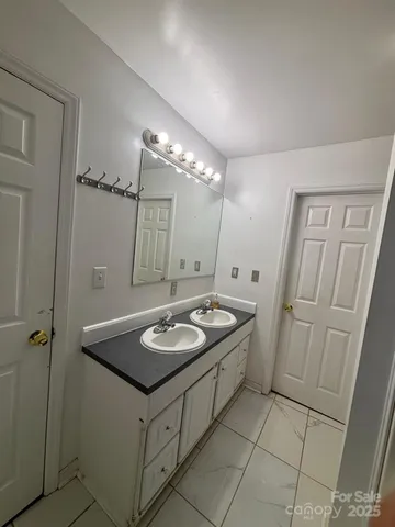 a bathroom with a granite countertop sink a mirror and a shower