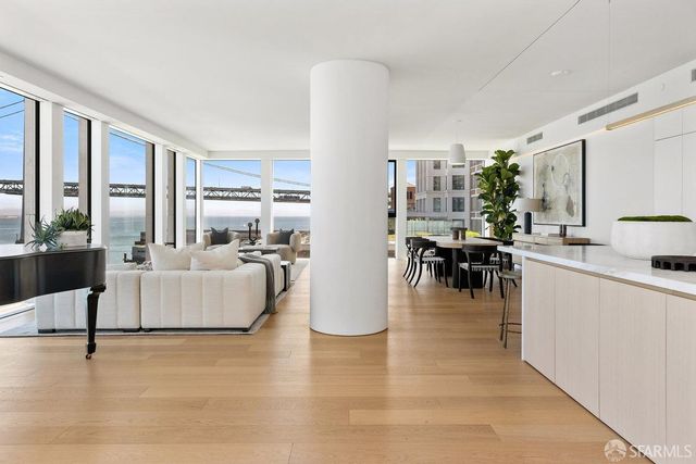 a living room with furniture floor to ceiling window and a table