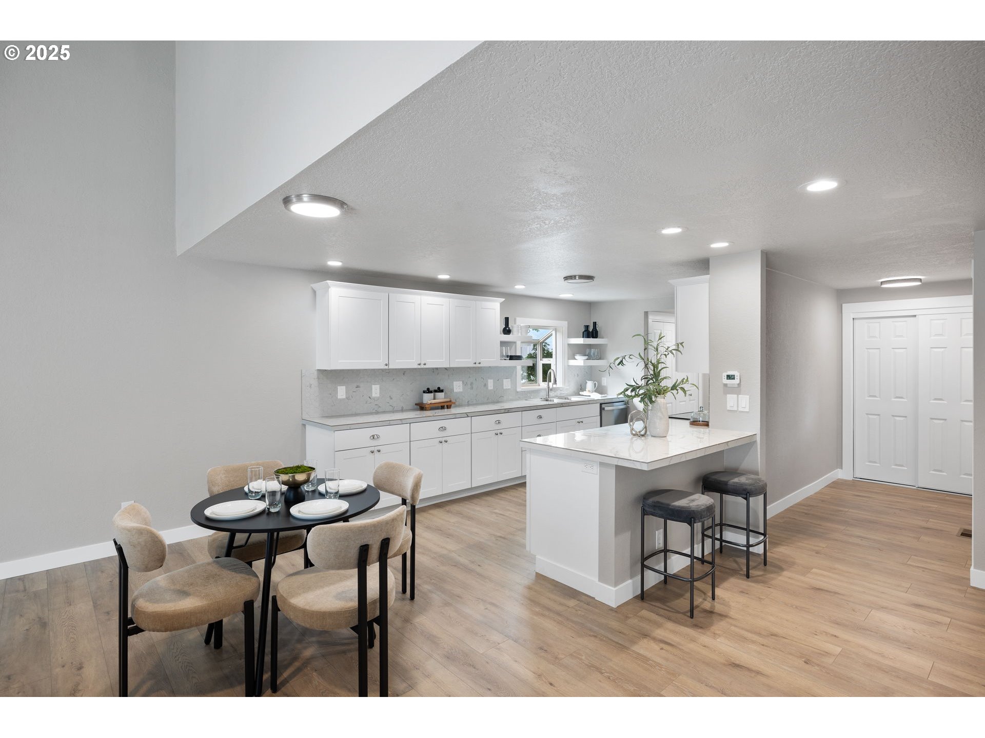 3240 Northeast 29th Street Gresham, OR 97030 - Photo 9 of 29 a kitchen with kitchen island a dining table chairs and white cabinets