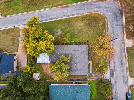 an aerial view of a residential houses with yard