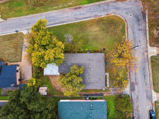 an aerial view of a residential houses with yard