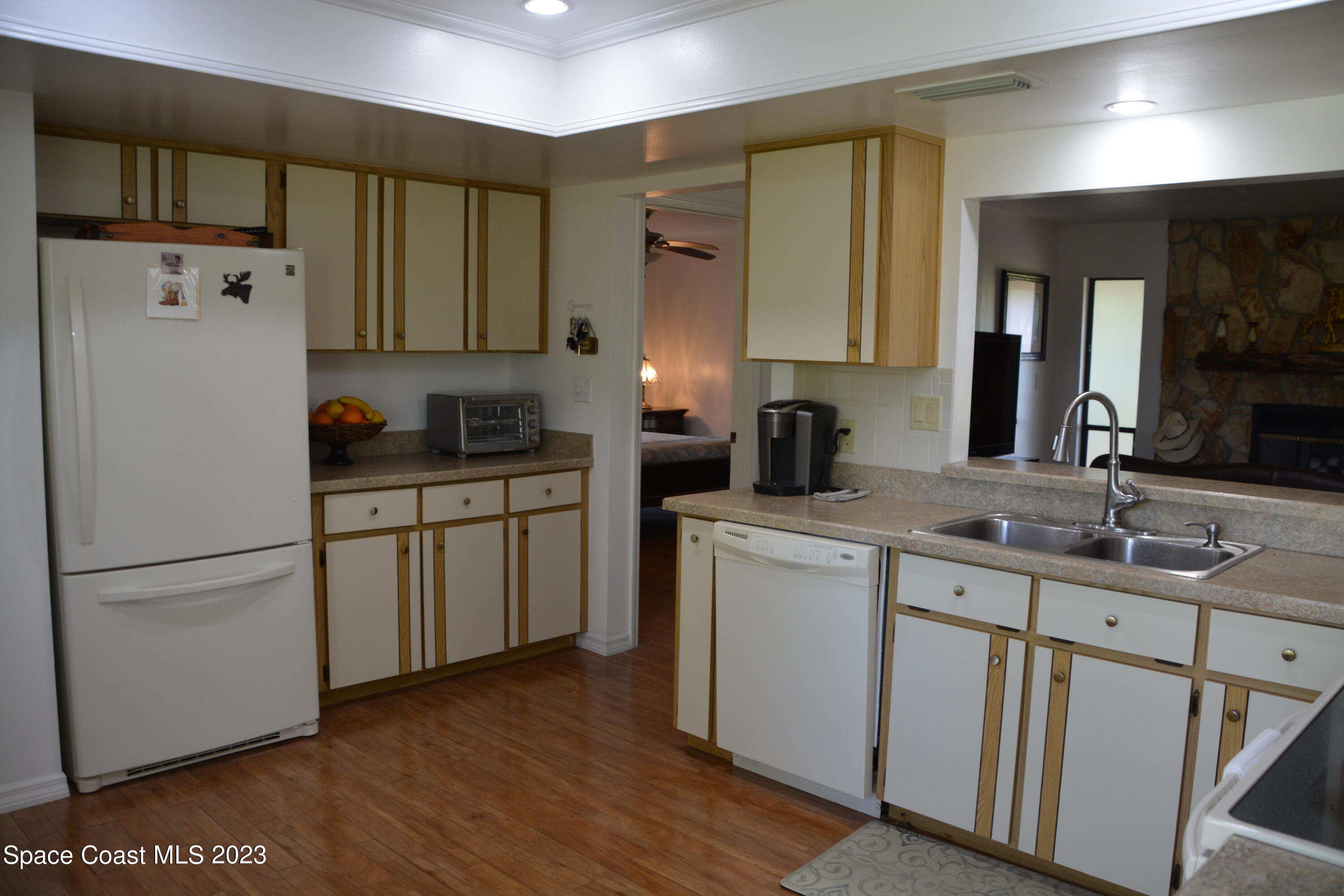1045 Pine Island Road Merritt Island, FL 32953 - Photo 13 of 42 a kitchen with a sink a refrigerator a cabinets and wooden floor