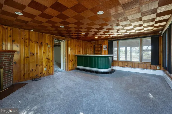 an empty room with wooden floor & windows