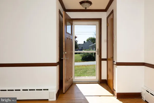 a view of entryway and hall with wooden floor