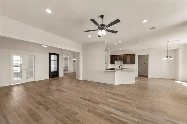 a view of a livingroom with a flat screen tv wooden floor and a ceiling fan