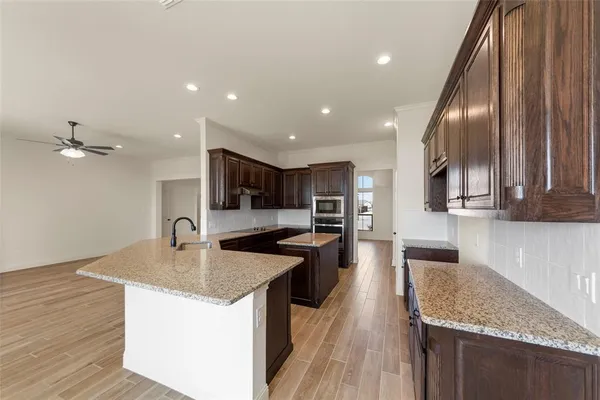 a kitchen with stainless steel appliances granite countertop a sink refrigerator and cabinets
