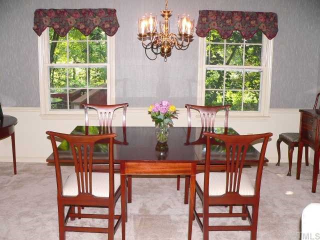 5404 Fairoaks Road Durham, NC 27712 - Photo 3 of 12 a dining room with furniture a large window and a chandelier