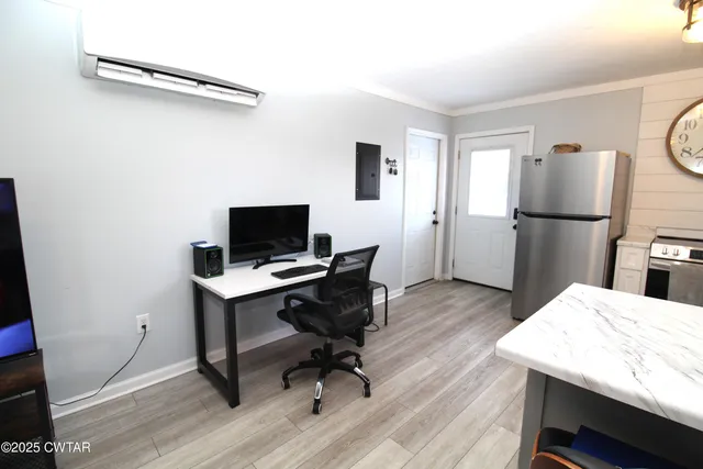 a view of a workspace with furniture and wooden floor