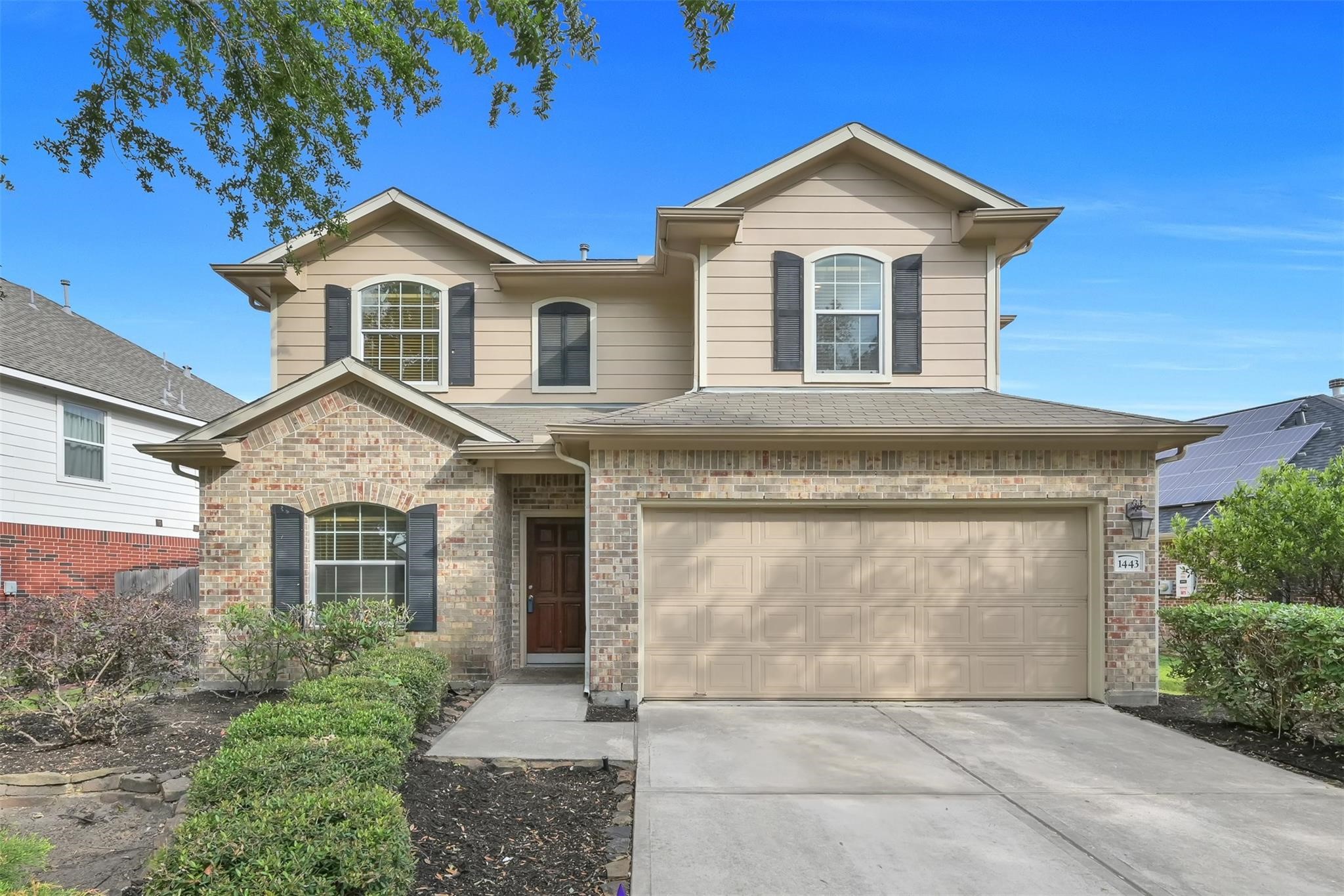 1443 Meadowhigh Lane Spring, TX 77373 - Photo 1 of 23 a front view of a house with a garden and trees