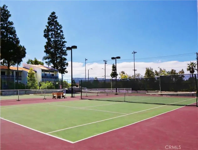 a view of a tennis ground with large trees