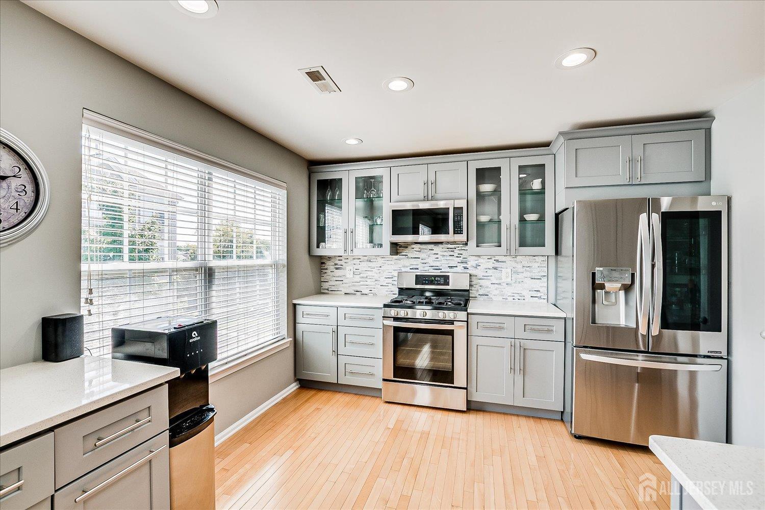 39 Rojewski Way Sayreville, NJ 08859 - Photo 15 of 40 a kitchen with stainless steel appliances granite countertop a stove a sink dishwasher a refrigerator and a microwave oven with wooden floor