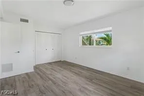 an empty room with wooden floor and window