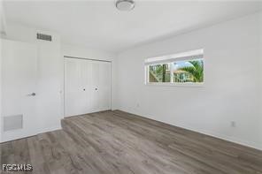 16001 Buccaneer Street, Unit 3 Bokeelia, FL 33922 - Photo 11 of 14 an empty room with wooden floor and window