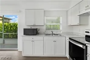 a kitchen with granite countertop white cabinets and a sink