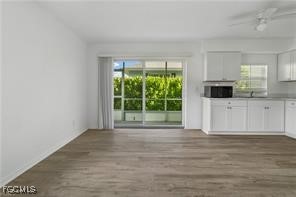 16001 Buccaneer Street, Unit 3 Bokeelia, FL 33922 - Photo 5 of 14 a view of livingroom with furniture flat screen tv and floor to ceiling window