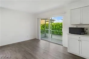 a view of a kitchen with wooden floor and cabinets