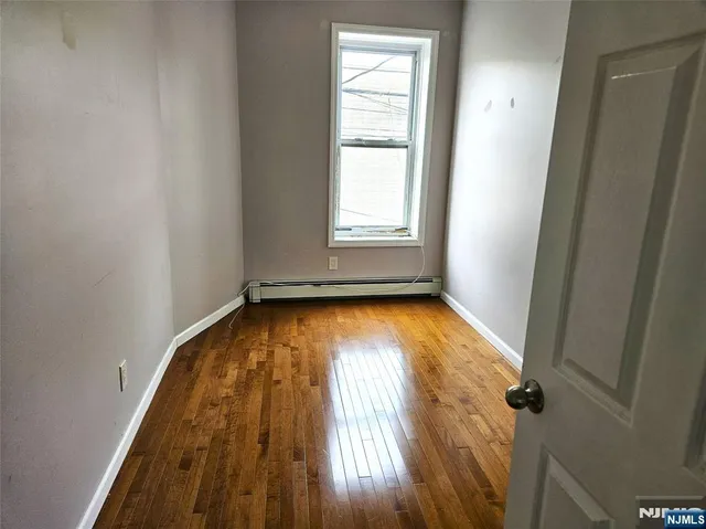 an empty room with wooden floor and a window