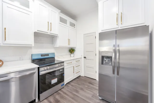 a kitchen with cabinets stainless steel appliances and wooden floor