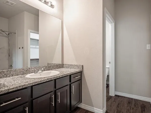 a bathroom with a granite countertop sink and a mirror