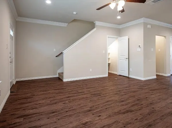 an empty room with wooden floor and chandelier