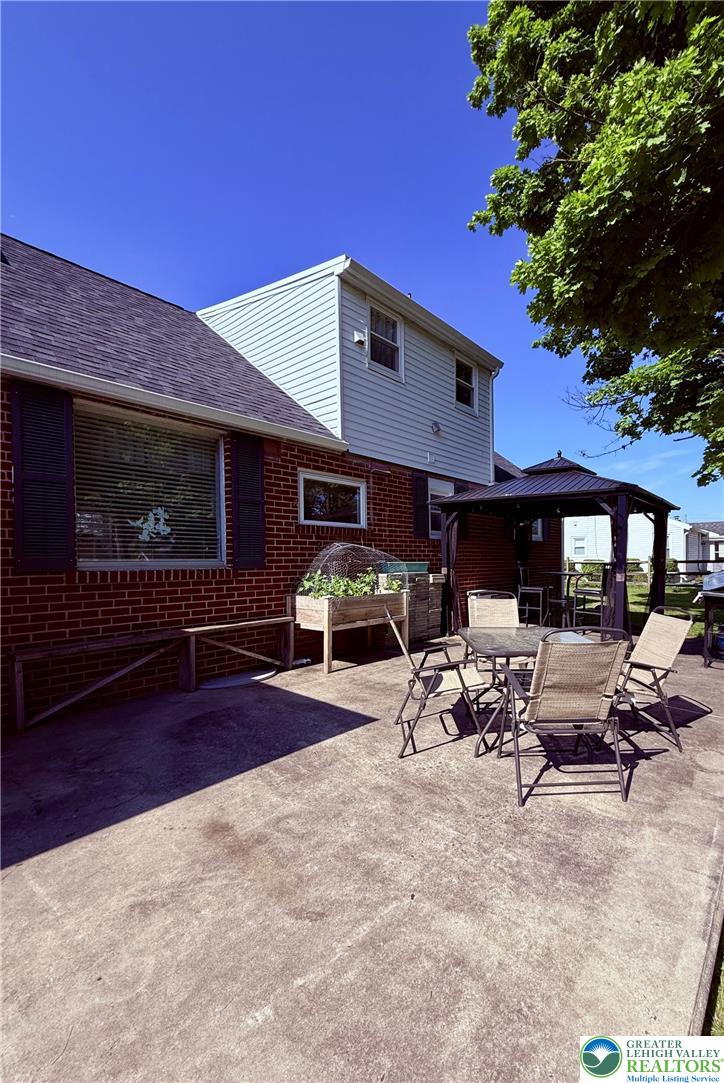 1275 Macada Road Bethlehem, PA 18017 - Photo 4 of 87 a view of a patio with table and chairs with a fire pit and potted plants