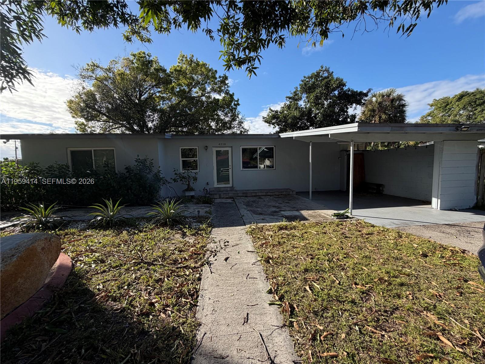4210 Southwest 10th Street Plantation, FL 33317 - Photo 2 of 19 a house with trees in the background
