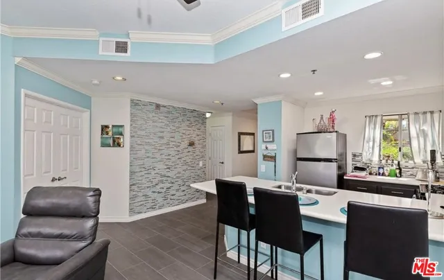 a kitchen with stainless steel appliances kitchen island granite countertop a dining table and chairs