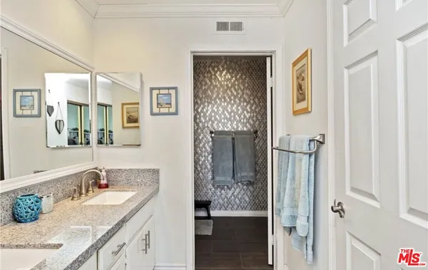 a bathroom with a granite countertop sink a mirror and shower