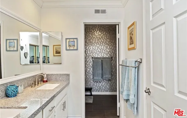 a bathroom with a granite countertop sink a mirror and shower