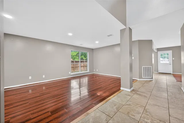 a view of empty room with wooden floor