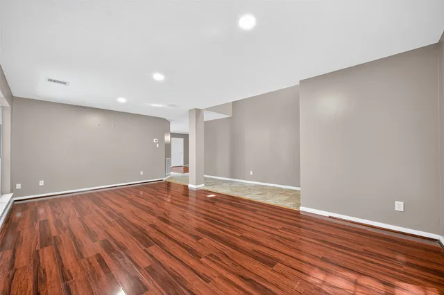 a view of an empty room with wooden floor