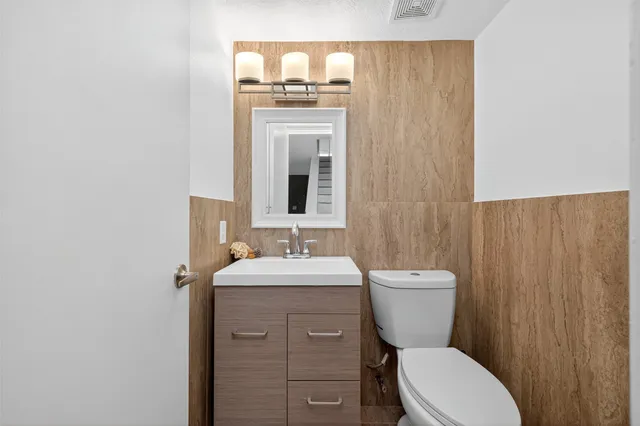 a bathroom with a toilet a sink and mirror