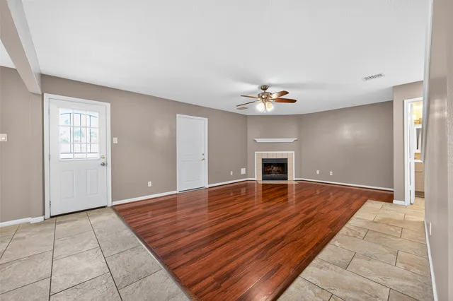 a view of empty room with wooden floor and fireplace
