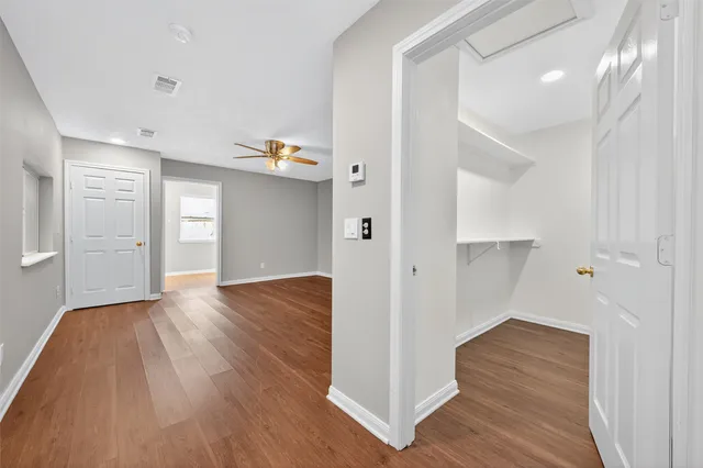a view of empty room with wooden floor