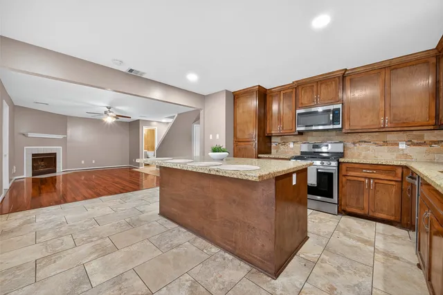a kitchen with stainless steel appliances granite countertop a stove a sink and a microwave