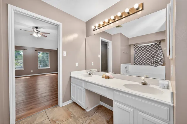 a spacious bathroom with a sink a large mirror and vanity