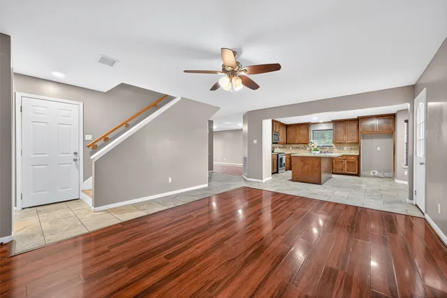 a view of a kitchen with wooden floor and a ceiling fan