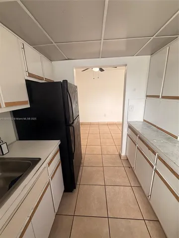 a kitchen with a refrigerator and a sink