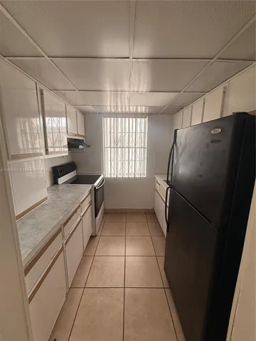 a kitchen with a refrigerator a sink and cabinets