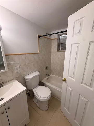 a white toilet sitting next to a bath tub