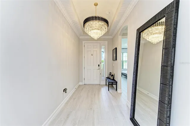 a living room with furniture floor to ceiling window and wooden floor