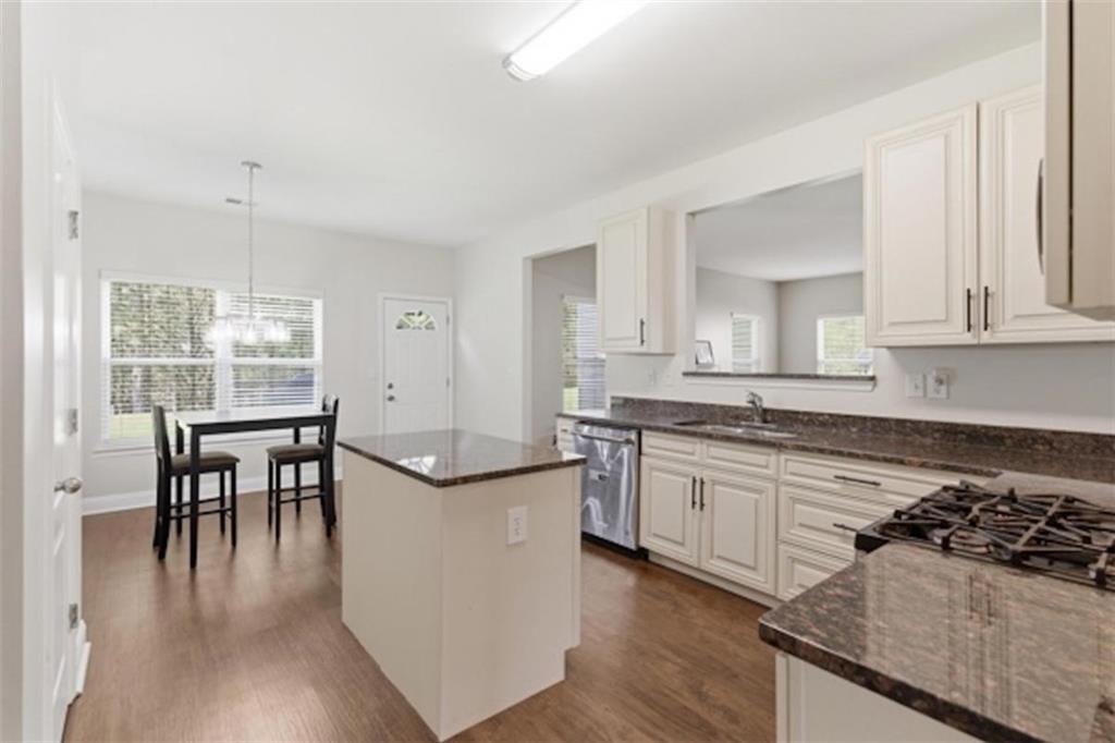4925 Locherby Drive Fairburn, GA 30213 - Photo 16 of 85 a kitchen with stainless steel appliances granite countertop a stove and a wooden floors