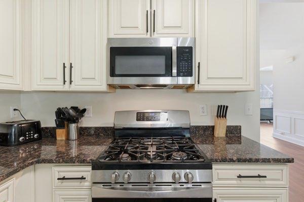4925 Locherby Drive Fairburn, GA 30213 - Photo 19 of 85 a kitchen with stainless steel appliances granite countertop white cabinets and a stove a oven with white countertops