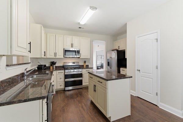 4925 Locherby Drive Fairburn, GA 30213 - Photo 20 of 85 a kitchen with granite countertop a sink stove and refrigerator