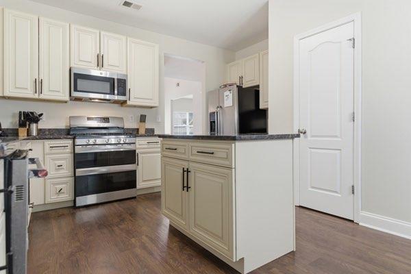 4925 Locherby Drive Fairburn, GA 30213 - Photo 21 of 85 a kitchen with stainless steel appliances a stove and a refrigerator
